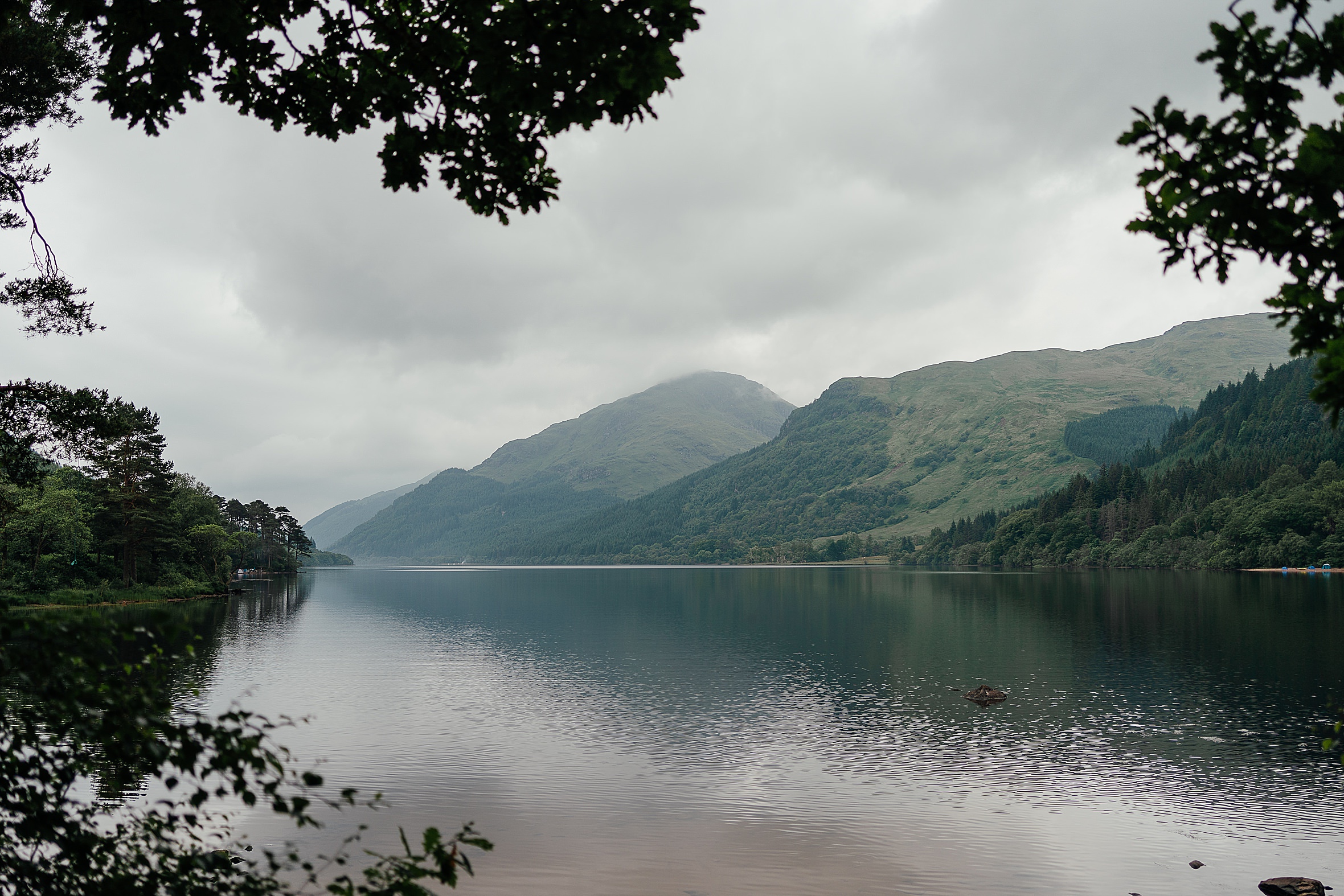 view of loch with mountains in the background grey clouds in the sky elope to argyll fotomaki photography